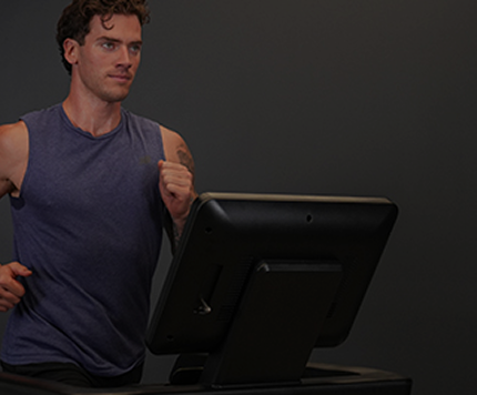 Male athlete running on a treadmill in a gym setting.